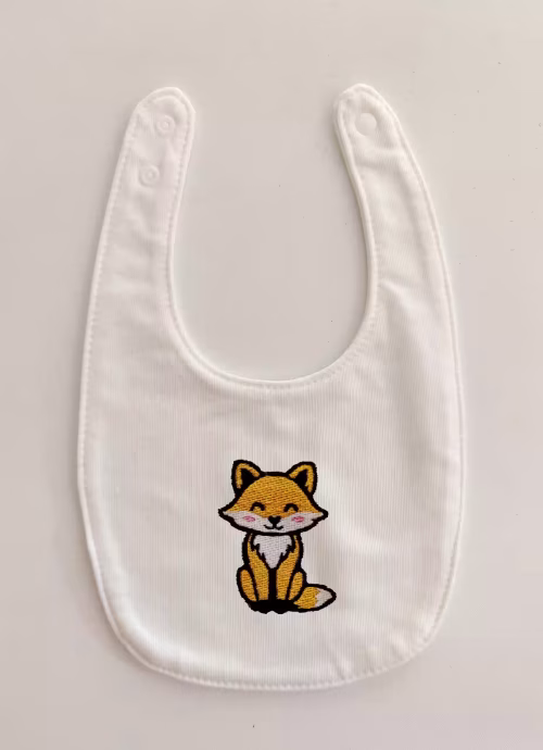 Fotografia di un bavaglino per neonato con una volpe ricamato sulla parte centrale.